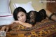 A woman laying on a bed in a black lingerie.