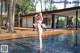 A woman in a pink bikini standing in a pool.