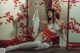 A woman in a red and white outfit sitting on the ground.