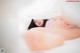 A woman laying on a bed under a white sheet.