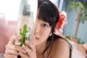 A woman holding a bottle with a cactus in it.
