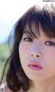 A close up of a woman's face in a field.